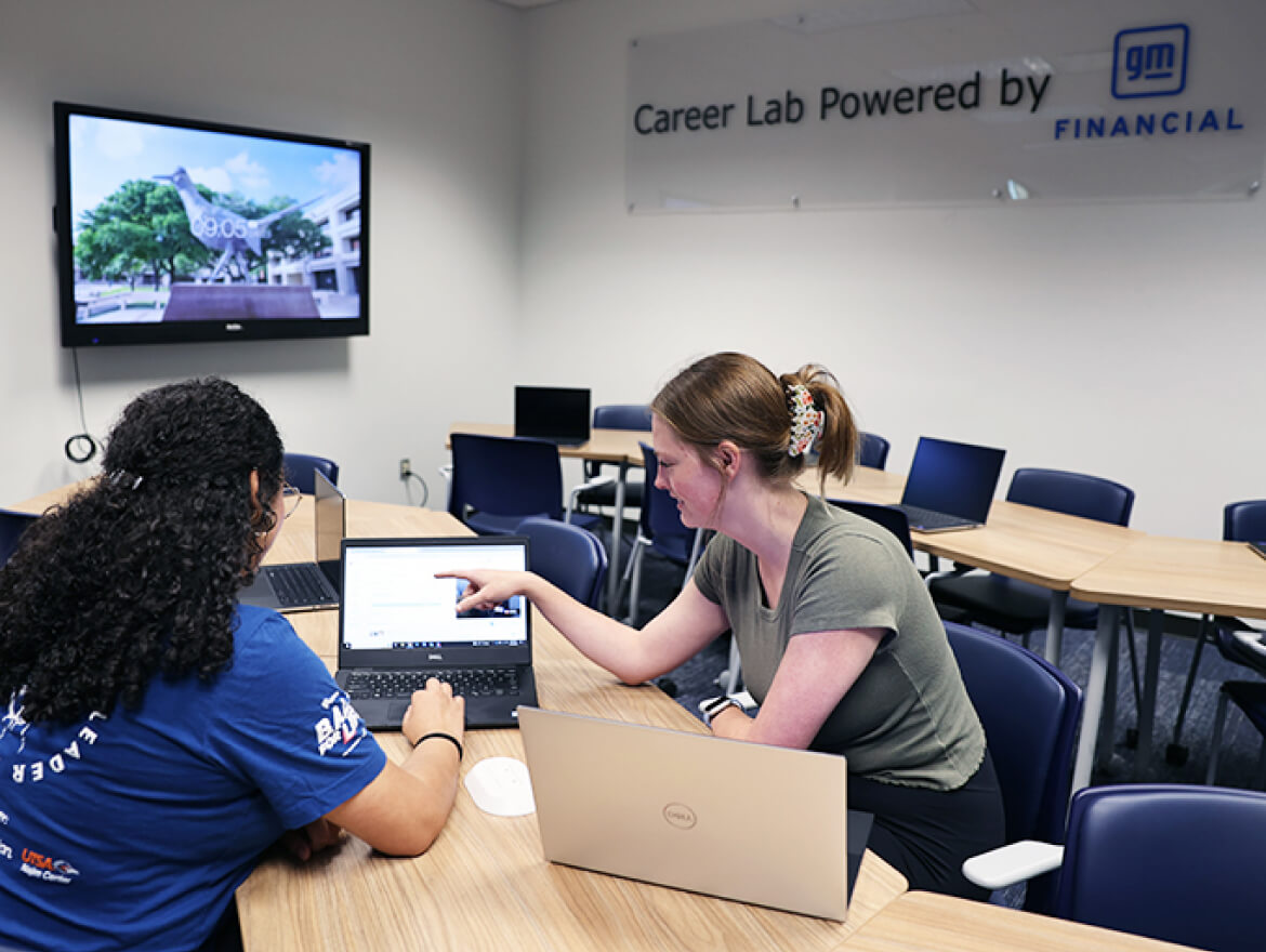 Students on a table working on a laptop at the UTSA Career Lab Powered by GM Financial