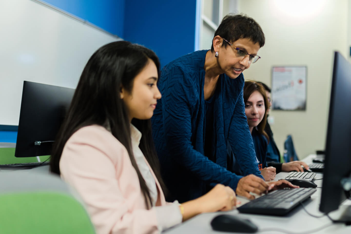 Instructor with 2 female students working on their computers